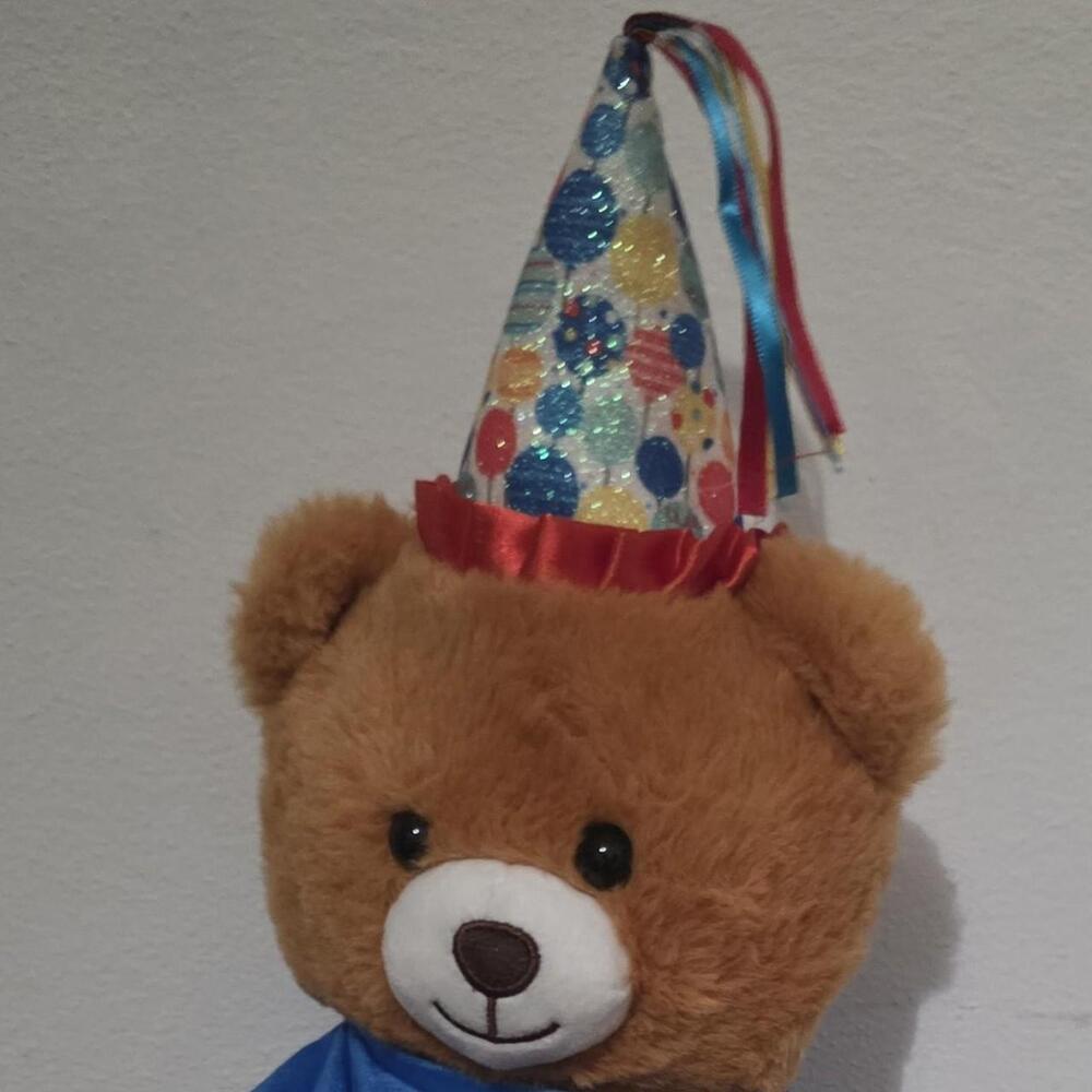 Brown teddy bear with a party hat featuring colorful balloons and confetti #part